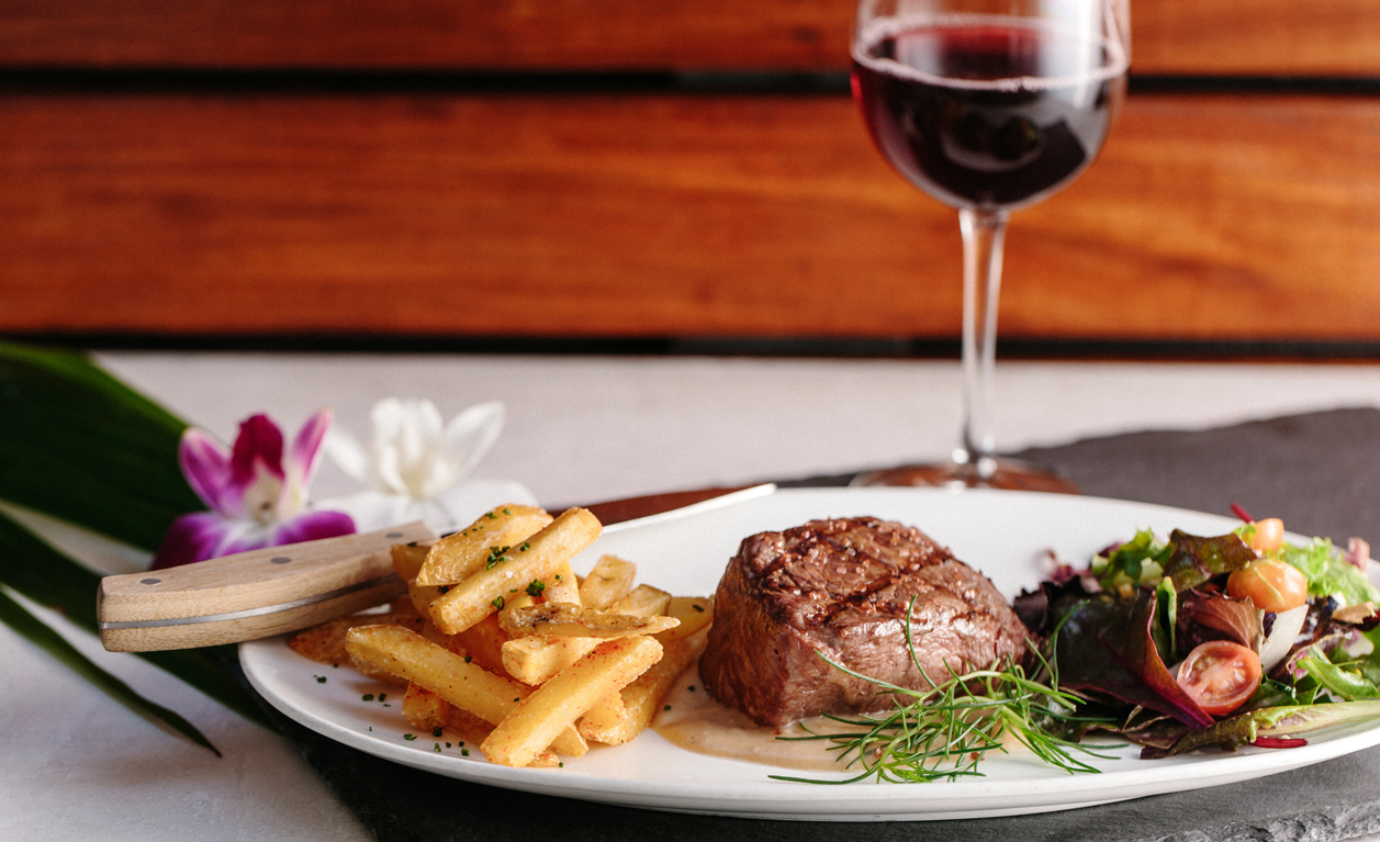 Steak, fries, and salad with wine