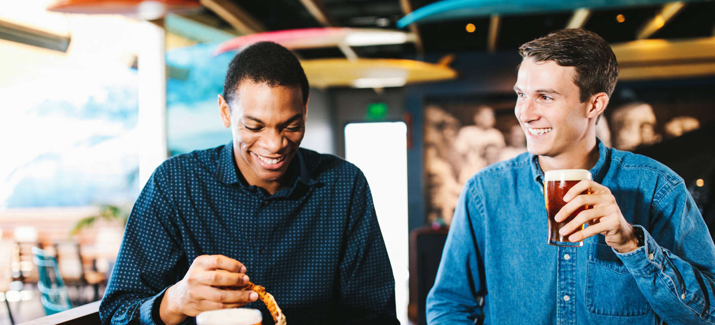 Two men drinking beer and eating